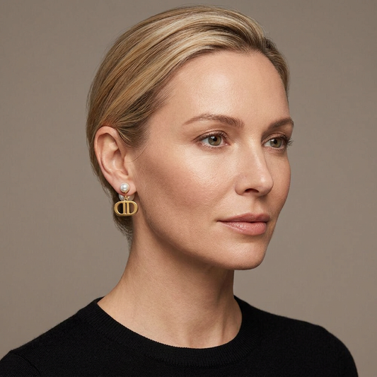 Model wearing gold double-D drop earrings with white pearl studs and larger rear pearls.