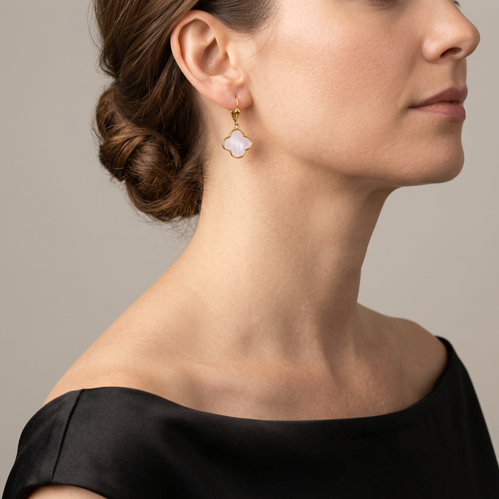 Gold leverback earrings with mother of pearl clover charms worn with a black evening gown