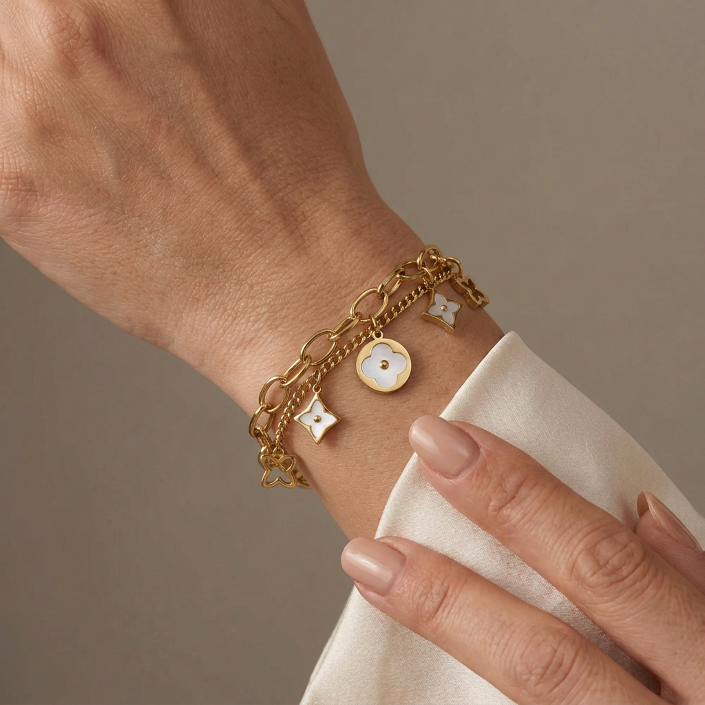Gold double-layer mother-of-pearl clover bracelet worn on a model’s wrist.