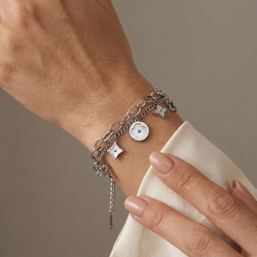 Silver double-layer mother-of-pearl clover bracelet worn on a model’s wrist.