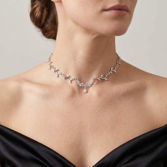 Silver leaf vine necklace with clear crystals and a small central teardrop worn with a black satin gown