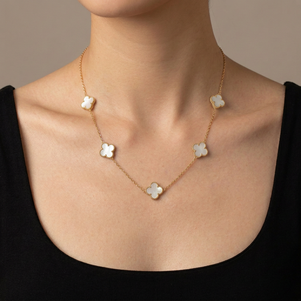 Model wearing a gold necklace with five white mother-of-pearl clover motifs.