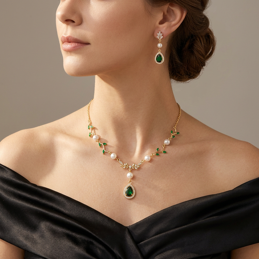 Green leaf pearl necklace and matching green teardrop earrings worn together with a black satin gown